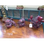 A pair of red resin figures of foo dogs, 10 cm high, and another of a koi, 16 cm high (3)