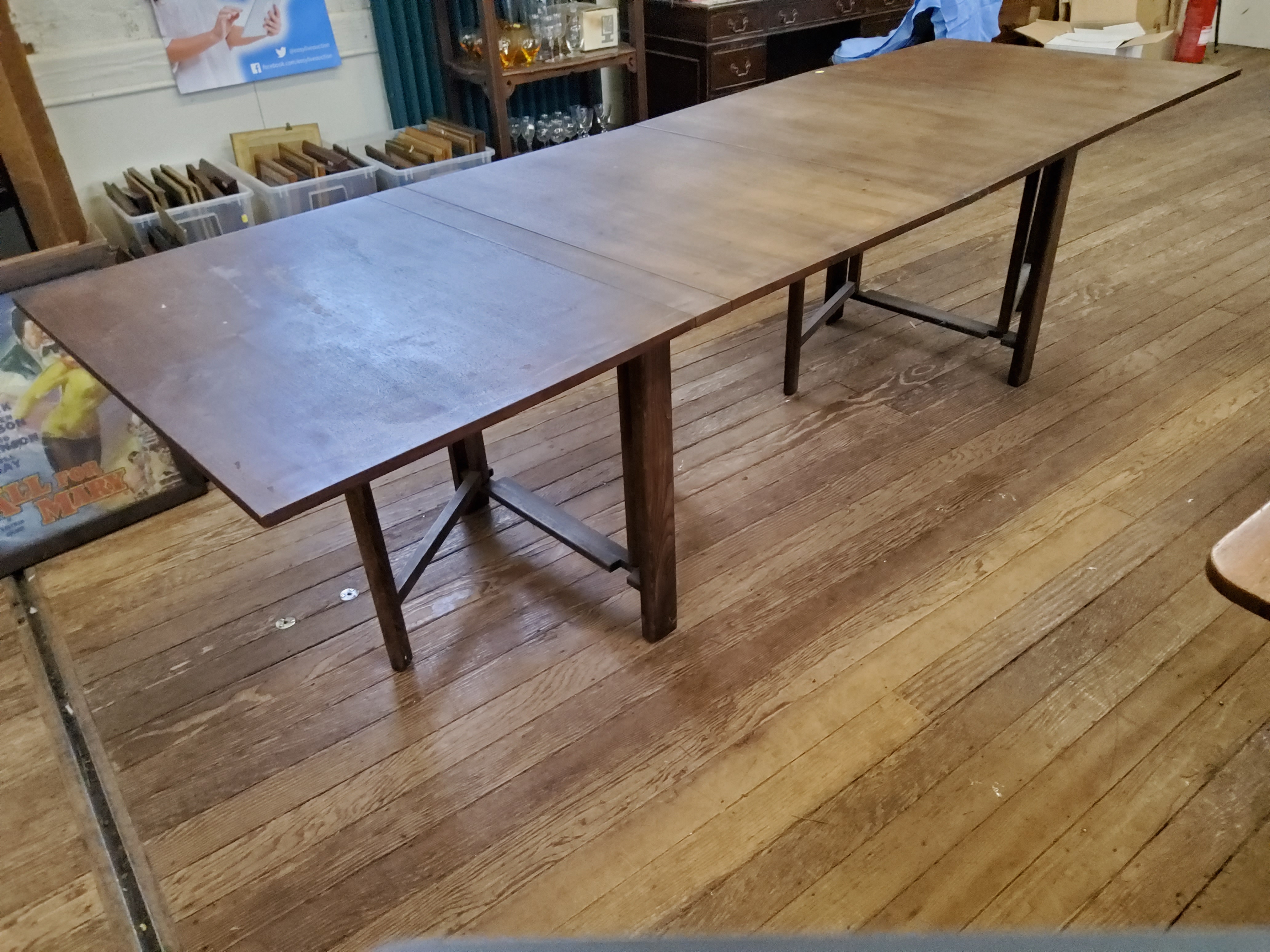 A teak extending sutherland style dining table, the rectangular top formed of four hinged drop