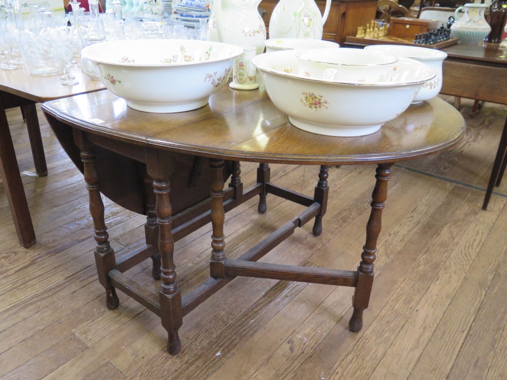 An oak gateleg table, the oval top on turned and block legs, joined by stretchers, 106 cm wide