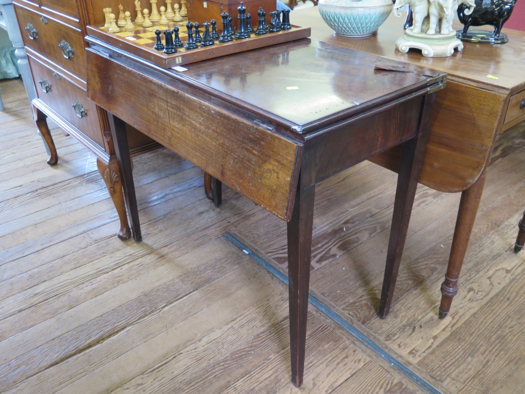 A mahogany foldover tea table, with a drop leaf to the front, covering a frieze drawer, on square