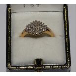 A diamond cluster ring set in 18 carat yellow gold