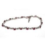 A ruby and diamond bracelet set in 14 carat white gold