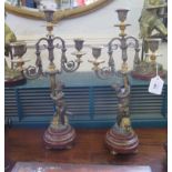 A pair of bronze and gilt metal three light candelabra, the scrolling branches held aloft by putti