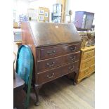 A 1930s mahogany bureau, the sloping fall with fitted interior, over three long drawers on