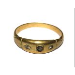 A yellow metal ring set with three paste stones