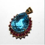A blue stone and ruby set pendant on 14 carat gold