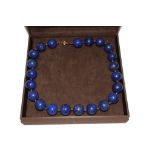 A single row necklace of large uniform size lapis lazuli beads, in a case