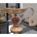 A Chinese export style jug, with entwined handle, enamelled floral sprays and coat of arms, 13 cm