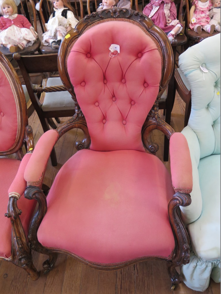 A Victorian walnut gentleman's armchair, the spoon shape button back with scroll arms foliate carved