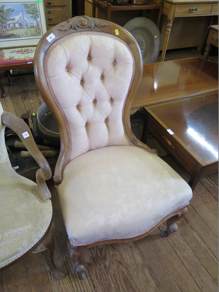 A Victorian walnut nursing chair, the cabochon carved button back on moulded cabriole legs and pot