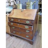 An early 19th century mahogany bureau, the sloping fall enclosing pigeon-holes and drawers, over