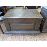 A continental oak coffer, the hinged lid over a panelled front and broad moulding on stile feet, the