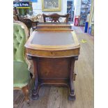 A Victorian walnut Davenport desk, the hinged top enclosing a fitted interior over a leatherette