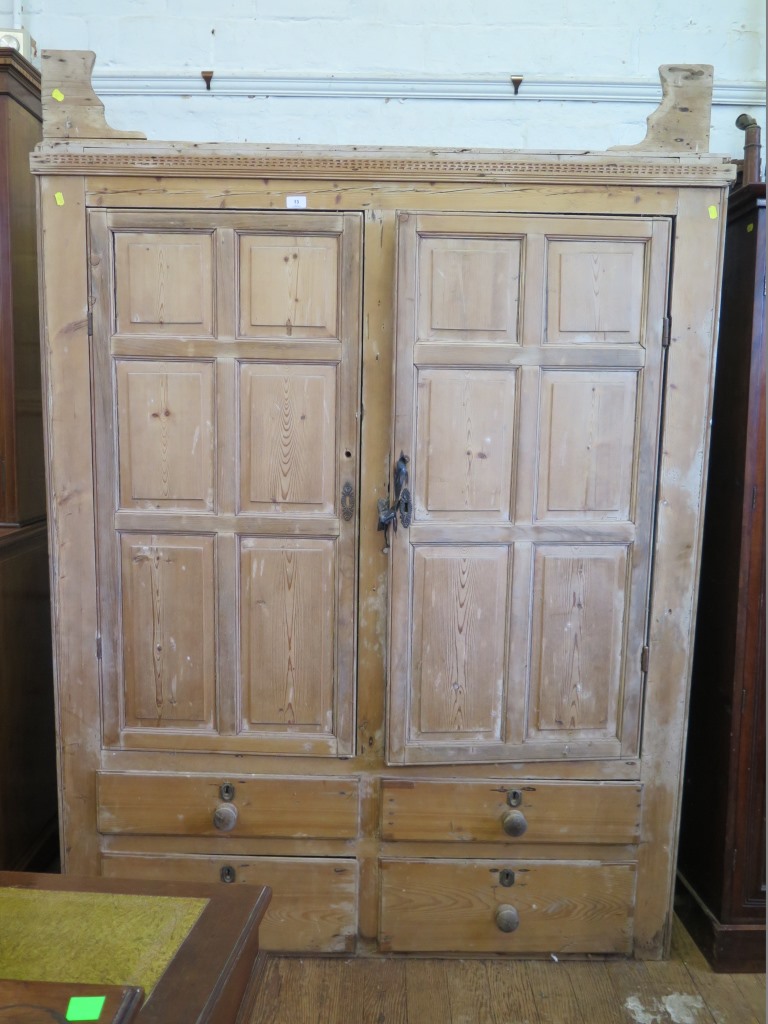 A 19th century pine kitchen cupboard, the pair of panelled doors enclosing shaped shelves, over four