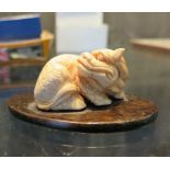 A Japanese ivory carving on stand of an angry foo dog, 4.5 cm long
