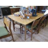 A set of six 1970s teak dining chairs, with broad top rails and padded seats, on turned legs, and