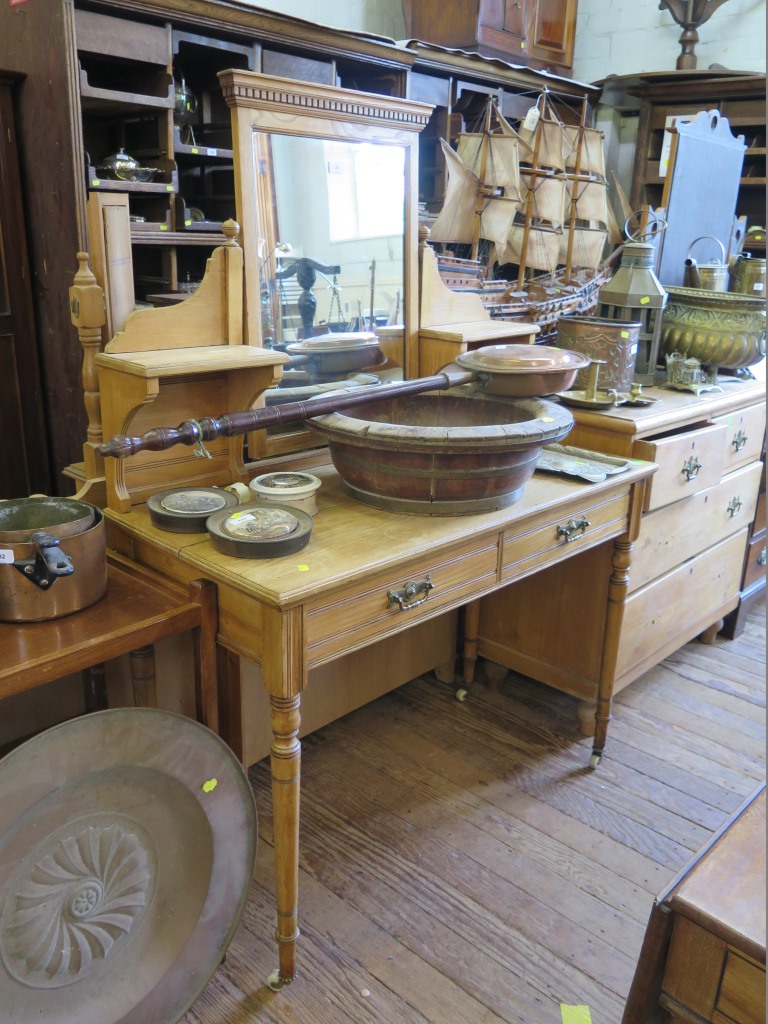 An Edwardian pine dressing table, the swing mirror and shelves over two frieze drawers on ring