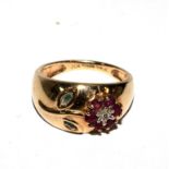 A 9 carat gold ring set with ruby and diamond flower