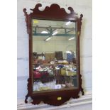 A George II style mahogany fret carved wall mirror, with gilt slip and rectangular plate, 39 x 65 cm