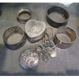 A small collection of silver items to include heart shape pill box, three napkin rings, and a modern