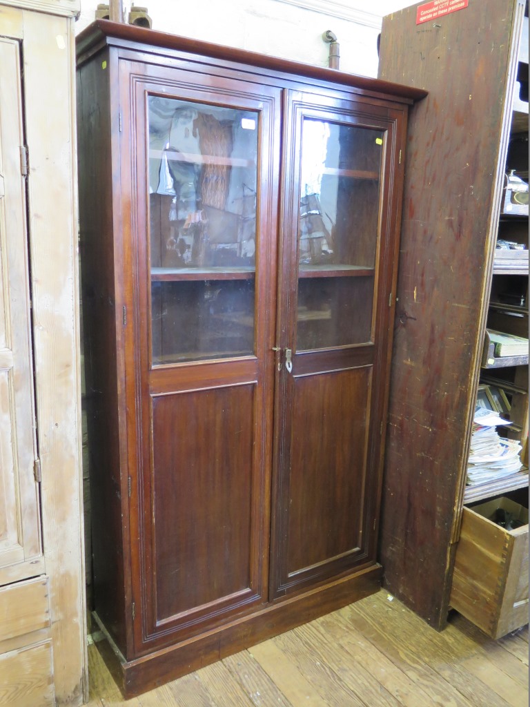 A mahogany bookcase, with twin glazed and panelled doors, 101 cm wide, 30 cm deep, 168 cm high