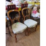A pair of late Victorian walnut balloon back dining chairs, with carved mid rails, overstuffed seats