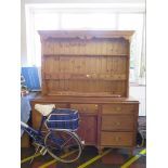 A pine dresser with associated rack, the rack with trinket drawers, 137 cm wide, over a dresser with