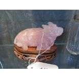 A carving in rose quartz of a water buffalo on a carved wooden stand (slight damage to one ear),