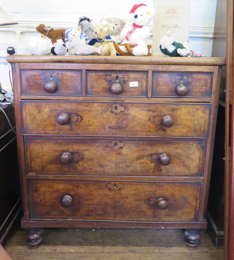 A walnut chest of drawers, with three short and three long graduated featherbanded drawers, on