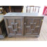 A panelled oak cupboard, the hinged lid over a pair of panelled cupboard doors enclosing dummy