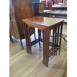 An Edwardian chevron banded mahogany nest of three tables, the rectangular tops on square tapering