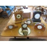 Four Edwardian inlaid desk timepieces, a mid Victorian slate mantel clock and another mantel