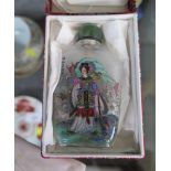 A Chinese glass scent bottle, with jade stopper and decorated with a figure walking in a