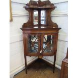 An Edwardian inlaid rosewood corner cabinet, the raised galleried top with bevelled mirror back over