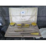 A cased six piece ladies dressing table set finished in silver and yellow enamel (two pieces