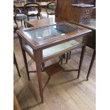 An Edwardian satinwood crossbanded mahogany bijouterie table, the hinged glazed top on square