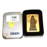 An Indian Chief Cigars brass Zippo lighter, with engraved initials, and tin box