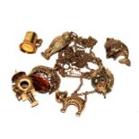 A selection of gold charms to include a spinning seal, a lantern, an owl, etc