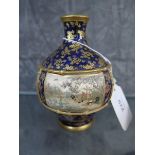 A Japanese Satsuma vase, the blue foliate decorated ground with panels depicting village scenes,