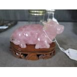 A carving in rose quartz of a water buffalo on a carved wooden stand (slight damage to one ear),