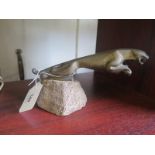 A brass Jaguar car mascot, mounted on a plaster base, 19 cm long