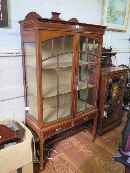 An Edwardian boxwood and ebony strung mahogany display cabinet, the shaped back over a pair of