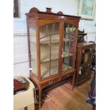 An Edwardian boxwood and ebony strung mahogany display cabinet, the shaped back over a pair of