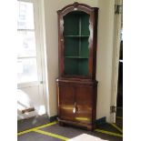 A burr walnut corner cabinet, the moulded top over two shaped open shelves above a pair of