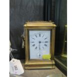 An Edwardian brass carriage clock, with bevelled glass, the enamel dial with subsidiary alarm