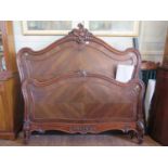 A French 19th century rosewood double bed, the shaped quarter veneered boards carved with foliate