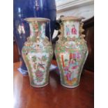 A pair of Chinese famille rose vases, of inverted baluster form and applied with dragons, the panels