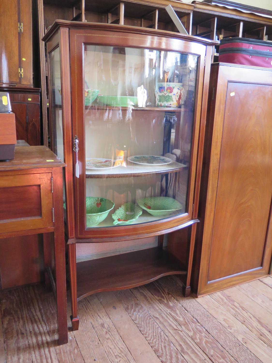 An Edwardian mahogany chequerbanded bowfront display cabinet, on square section tapering legs joined