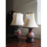 Two Moorcroft Pottery table lamps, Poppy design and another floral design, on turned wood bases,