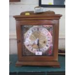 An oak cased mantel clock, retailed by Ridgeway, the caddy top over a brass dial and silvered